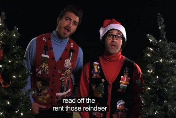 Two men appearing to sing "Rudolph the Red Nosed Reindeer" with closed-caption words "read off the rent those reindeer."